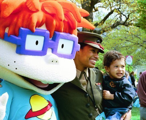 A United States Marine and her son stand for pictures with Chuckie, a character from the cartoon, "Rugrats," during the White House Easter Egg Roll Monday, April 21, 2003. More than 30 children's characters wandered through the South Lawn during the day's festivities, including Clifford the Big Red Dog, Winnie the Pooh and the Berenstain Bears. File photo. White House photo by Jennifer Smith