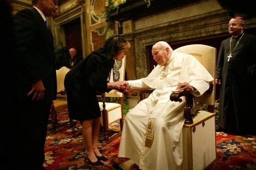 Mrs. Bush takes the hand of Pope John Paul II during the June 2004 visit to Rome by she and President Bush during which they presented the Pope with the Medal of Freedom White House photo by Eric Draper