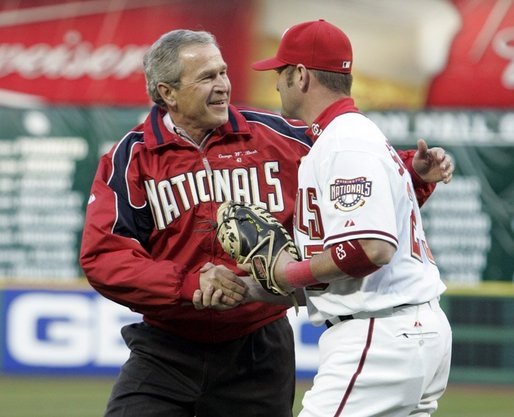 President George W. Bush is congratulated by catcher Brian Schneider after throwing the opening pitch of the Washington DC Nationals home opener at RFK Stadium in Washington DC on Thursday April 14 2005. White House photo by Paul Morse