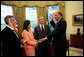 White House Chief of Staff Andrew Card swears in John Negroponte as the first Director of National Intelligence as President George W. Bush looks on Thursday, April 21, 2005, in the Oval Office. Dina Powell, Assistant to the President for Presidential Personnel, holds the Bible. White House photo by Eric Draper