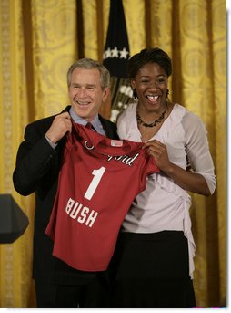 Ogonna Nnamani presents President George W. Bush with a team jersey from the Stanford University Women’s volleyball team during a ceremony celebrating the 2005 NCAA champions in the East Room Friday, May 13, 2005.  White House photo by Eric Draper