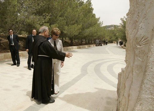 Father Michele Piccirillo, head of the Franciscan Archeology Society, discusses a monument with Laura Bush during her tour of Mount Nebo in Jordan Saturday, May 21, 2005. White House photo by Krisanne Johnson