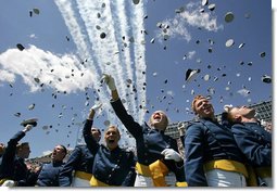 Graduates toss their hats into the air as the contrails from five F-16's stream overhead during the U.S. Air Force Academy graduation in Colorado on Wednesday, June 1, 2005. Nine-hundred and six graduates became commissioned officers in the U.S. Air Force after their four-year curriculum that began shortly before Sept. 11, 2001.  White House photo by David Bohrer
