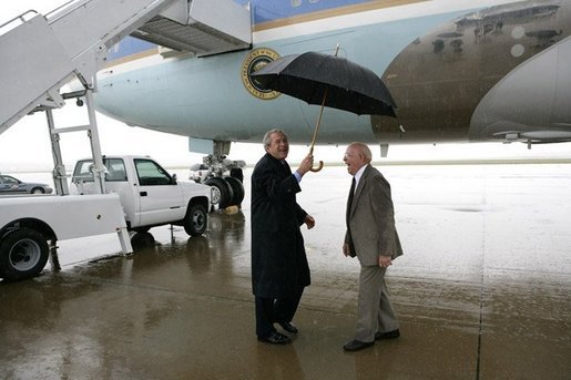 President George W. Bush shares an umbrella and a laugh Thursday, June 2, 2005, at Fort Campbell, Ky., with Freedom Corps greeter Dr. John Cotthoff, an 81-year-old volunteer physician at the St. Luke Free Clinic in nearby Hopkinsville. White House photo by Eric Draper