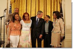 President George W. Bush celebrates Black Music Month Monday, June 6 2005, in the East Room of the White House. With him from left are artists: Reverend Donnie McClurkin; sisters Erica and Tina Campbell of Mary Mary; Smokie Norful, and Teresa Hairston, founder an publisher of Gospel Today and emcee of the event.  White House photo by Krisanne Johnson