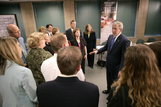 President George W. Bush talks with training volunteers for Medicare enrollment during a visit Friday, June 17, 2005, to a training session at the Maple Grove Community Center in Maple Grove, Minn. White House photo by Eric Draper