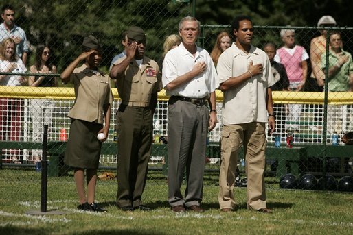 President George W. Bush is joined by Barry Larkin, White House Tee Ball Commissioner of the Game and Young Marines as they stand for the National Anthem Sunday, June 26, 2005, during "Tee Ball on the South Lawn." White House photo by Krisanne Johnson