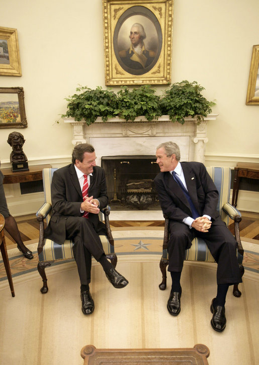 President George W. Bush and German Chancellor Gerhard Schroeder talk just before meeting with the press in the Oval Office Monday, June 27, 2005. White House photo by Eric Draper