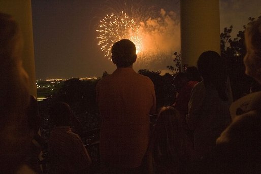 President George W. Bush watches Fourth of July fireworks from the balcony of the White House Monday evening. The Independence Day celebration was preceded by a birthday fete for the President, who will turn 59 on July 6. White House photo by Krisanne Johnson