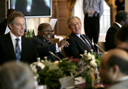 President George W. Bush shares a light moment with Tanzanian President Benjamin Mkapa during the morning session of the G8 Summit Friday, July 8, 2005, at Gleneagles Hotel in Auchterarder, Scotland. Britain's Prime Minister Tony Blair, who returned from London late last night, sits at left. White House photo by Eric Draper
