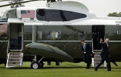 President George W. Bush waves as he and staff members arrive on the South Lawn Monday, July 11, 2005. White House photo by Lynden Steele