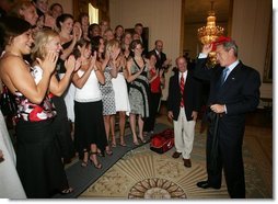 President Bush is applauded by members of the University of Georgia women's swimming and diving team, as he prepares put on the team hat Tuesday, July 12, 2005 at The White House, as part of ceremonies honoring the 2004 and 2005 NCAA Sport Championship teams.  White House photo by Eric Draper