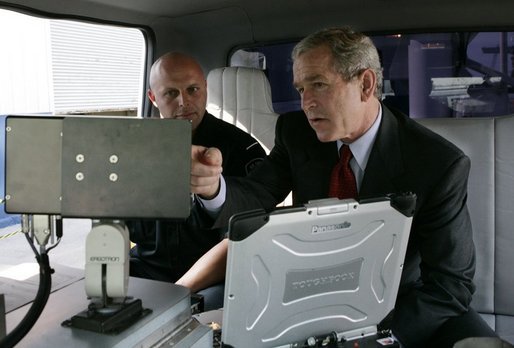President George W. Bush talks with a Homeland Security officer, Wednesday, July 20, 2005, as President Bush is shown mobile security scanning equipment during a customs and border protection demonstration at the Port of Baltimore in Baltimore, Md. White House photo by Eric Draper