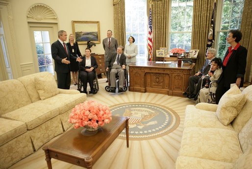 President George W. Bush gives a tour of the Oval Office after the signing of the Presidential Proclamation to Commemorate the 15th Anniversary of the Americans with Disabilities Act in the Oval Office Tuesday, July 26, 2005. President George H. W. Bush is pictured at center, left. White House photo by Eric Draper