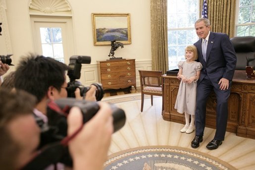 President George W. Bush and Navy Anderson, the 2005 March of Dimes National Ambassador, meet in the Oval Office, Wednesday, July 27, 2005 and pose for photographers. Navy Anderson, 7, and her family are in Washington to attend the March of Dimes National Youth Conference. White House photo by Eric Draper