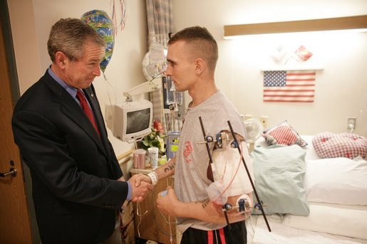 President George W. Bush shakes the hand of Marine Cpl. Anthony Gower after presenting him with a Purple Heart Saturday, July 30, 2005, at the National Naval Medical Center in Bethesda, Md. The Pittsburgh, Pa. native is recovering from injuries received in Operation Iraqi Freedom. White House photo by Eric Draper