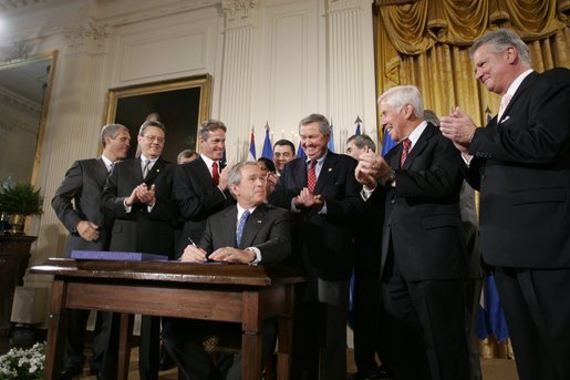 President George W. Bush acknowledges the applause of legislators and administration officials Tuesday, Aug. 2. 2005 in the East room of the White House, as he signs the CAFTA Implementation Act. White House photo by Paul Morse
