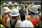 President George W. Bush talks with some workers of Alabama Power, who are helping to bring power back in service in Poplarville, Miss., Monday, Sept. 5, 2005. White House photo by Eric Draper