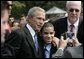 President George W. Bush poses for a photo with a young man wearing a button in honor of 9/11 victim, Yamel J. Merino, as he met some of the hundreds of families and friends who gathered on the South Lawn of the White House, Friday, Sept. 9, 2005, during the 9/11 Heroes Medal of Valor Award Ceremony, in honor of the courage and commitment of emergency services personnel who died on Sept. 11, 2001. White House photo by Eric Draper