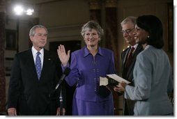 President George W. Bush watches as Karen Hughes is sworn-in by U.S. Secretary of State Condoleezza Rice, Friday, Sept. 9, 2005 at the State Department in Washington, to be the Under Secretary of State for Public Diplomacy. Jerry Hughes, Secretary Hughes' husband, holds the Bible during the ceremony.  White House photo by Eric Draper