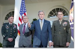 President George W. Bush addresses the media Wednesday, Oct. 5, 2005, in the Rose Garden, flanked by Gen. David Petraeus, former Commander of the Multinational Security and Transition Team in Iraq; Secretary of Defense Donald Rumsfeld, and Gen. Peter Pace, Chairman of the Joint Chiefs of Staff. White House photo by Paul Morse