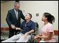 President George W. Bush shakes the hand of SFC Richard Robertson, of Knoxville, Tenn., Wednesday, Oct. 5, 2005, as his wife, Sarah Robertson, looks on. President Bush presented the Purple Heart to the soldier during his visit to Walter Reed Army Medical Center in Washington D.C. White House photo by Paul Morse
