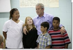 President George W. Bush spends a moment Tuesday, Oct. 11, 2005, with students at Delisle Elementary School in Pass Christian, Miss. The school reopened Tuesday for the first time since Hurricane Katrina devastated the Gulf Coast region.  White House photo by Eric Draper