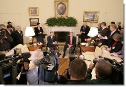 President George W. Bush and Poland's President Aleksander Kwasniewski meet with reporters in the Oval Office at the White House, Wednesday, Oct. 12, 2005 in Washington.  White House photo by Eric Draper