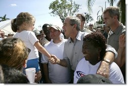 President George W. Bush greets local residents lined up at a food and water distribution center, Thursday, Oct. 27, 2005, in the hurricane damaged area of Pompano Beach, Fla.  White House photo by Eric Draper