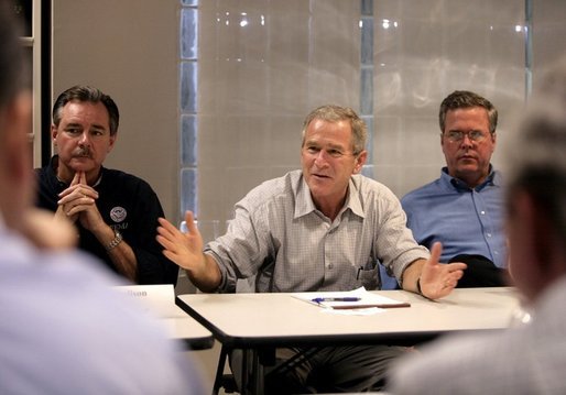 President George W. Bush addresses a meeting with local and state elected officials on hurricane damage, including FEMA Director R. David Paulison, left, and Florida Governor Jeb Bush, right, Thursday, Oct. 27, 2005, in Miami, Fla. White House photo by Eric Draper