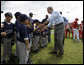 President George W. Bush greets players from the Meron's Academy Little League team in Panama City, Panama, Monday, Nov. 7, 2005. White House photo by Eric Draper