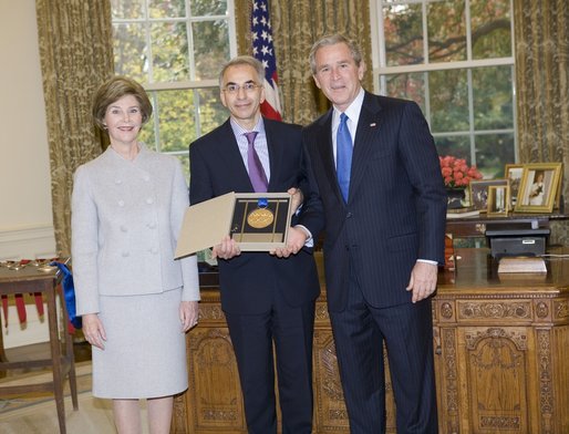 President George W. Bush and Laura Bush stand with Dereck Gillman, President of the Pennsylvania Academy of Fine Arts, who on the academy's behalf, was presented the 2005 National Medal of Arts, in the Oval Office Thursday, Nov. 10, 2005. White House photo by Eric Draper