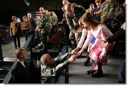 President George W. Bush reaches out to two girls after speaking Monday, Nov. 14, 2005, on the War on Terror at Elmendorf Air Force Base in Anchorage, Alaska.  White House photo by Paul Morse