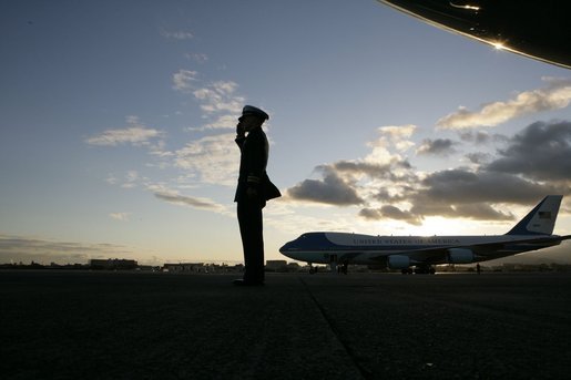 Air Force One sits on the tarmac at Osaka International Airport Wednesday, Nov. 16, 2005, as a military aide salutes the arrival of the President and Mrs. Bush. White House photo by Eric Draper