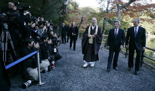 President George W. Bush and Japan’s Prime Minister Junichiro Koizumi join the Reverend Raitei Arima, Chief Priest of the Golden Pavilion Kinkakuji Temple in Kyoto, as they walk past the press during a cultural visit to the temple Wednesday, Nov. 16, 2005. White House photo by Eric Draper