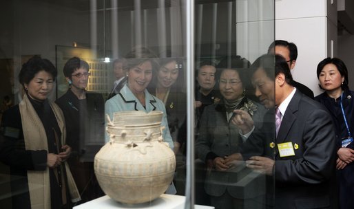 Mrs. Laura Bush looks through exhibition glass at a piece of pottery Thursday, Nov. 17, 2005, during her tour of Gyeongju National Museum in Gyeongju, Korea. With her at right is Mrs. Yang-Sook Kwon, wife of Korea President Moo Hyun Roh. White House photo by Shealah Craighead