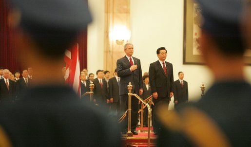 President George W. Bush and President Hu Jintao of China are viewed through the honor guard during welcoming ceremonies for the President and Mrs. Bush at the Great Hall of the People in Beijing. White House photo by Paul Morse