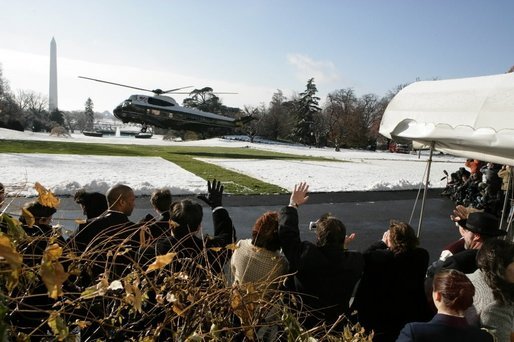 Visitors wave as President Bush takes off in Marine One from a snow-covered South Lawn Friday, Dec. 9, 2005. White House photo by Kimberlee Hewitt