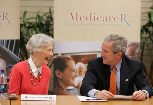 President George W. Bush smiles at 85-year-old Eloise Cartwright as he joins the residents of Greenspring Village Retirement Community and others for a roundtable discussion on the Medicare Prescription Drug Benefit Tuesday, Dec. 13, 2005, in Springfield, Va. White House photo by Paul Morse