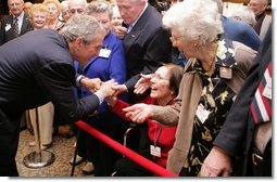 President George W. Bush bends to meet Jean Tessier of Tyson's Corner, Va., during his visit Tuesday, Dec. 13, 2005, to the Medicare Prescription Drug Educational and Enrollment Event at the Greenspring Village Retirement Community in Springfield, Va.  White House photo by Paul Morse