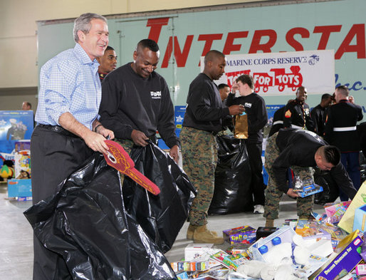 President George W. Bush helps U.S. Marines sort through a stack of toys Monday, Dec. 19, 2005 at the "Toys for Tots" collection center at the Naval District Washington Anacostia Annex in Washington, D.C. White House photo by Kimberlee Hewitt