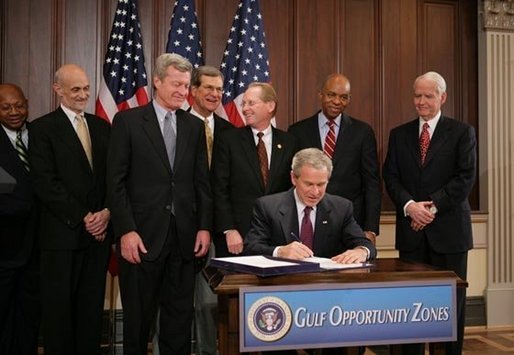 President George W. Bush signs H.R. 4440, the Gulf Opportunity Zone Act of 2005, Wednesday Dec. 21, 2005, as administration officials and legislative members join him for the signing ceremony held in the Dwight D. Eisenhower Executive Office Building in Washington. White House photo by Paul Morse