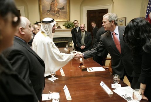 President George W. Bush exchanges handshakes with Mr. Mohammed Jaber during a visit at the White House Wednesday, Jan. 18, 2006, with victims of Saddam Hussein. Mr. Jaber is a former Iraqi journalist who was jailed for writing a story that raised questions about how oil money was being spent. White House photo by Eric Draper