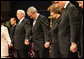 President George W. Bush and Mrs. Laura Bush are seen during a prayer holding hands with former President Bill Clinton, right, and Rev. Robert Schuller, left, at the homegoing celebration for Coretta Scott King, Tuesday, Feb. 7, 2006 at the New Birth Missionary Church in Atlanta, Ga. White House photo by Eric Draper