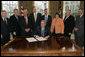 President George W. Bush is joined by legislators and the chairman of the Federal Deposit Insurance Corporation, Wednesday, Feb. 15, 2006 in the Oval Office, as he signs H.R. 4636- The Federal Deposit Insurance Reform Conforming Amendments Act of 2005. From left to right are U.S. Rep. Spencer Bachus, R-Ala., U.S. Sen. Tim Johnson, D-S.D., U.S. Sen Paul Sarbanes, D-Md., U.S. Sen. Richard Shelby, R-Ala., U.S. Rep. Mike Oxley, R-Ohio, U.S. Rep. Darlene Hooley, D-Ore., U.S. Sen. Mike Enzi, R-Wyo., and Martin Gruenberg, acting chairman of the Federal Deposit Insurance Corporation. White House photo by Kimberlee Hewitt