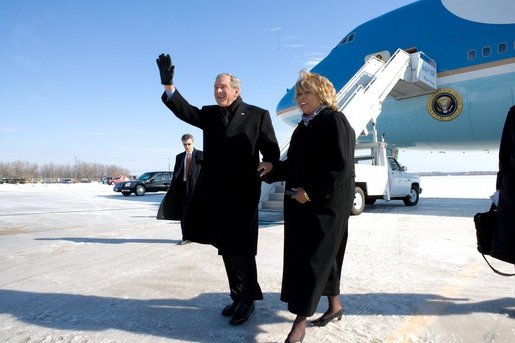 President George W. Bush escorts Freedom Corps Greeter Beverly Christy-Wright after his arrival in Milwaukee, Wisconsin, Monday, Feb. 20, 2006. The President presented Beverly with the President's Volunteer Service Award. White House photo by Eric Draper
