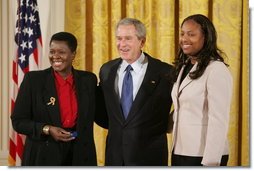 President George W. Bush is joined by Joan Thomas of Smyrna, Ga., left, and Erica Turner, who was mentored by Thomas, after Thomas received the President's Volunteer Service Award at a White House celebration of African American History Month.  White House photo by Paul Morse