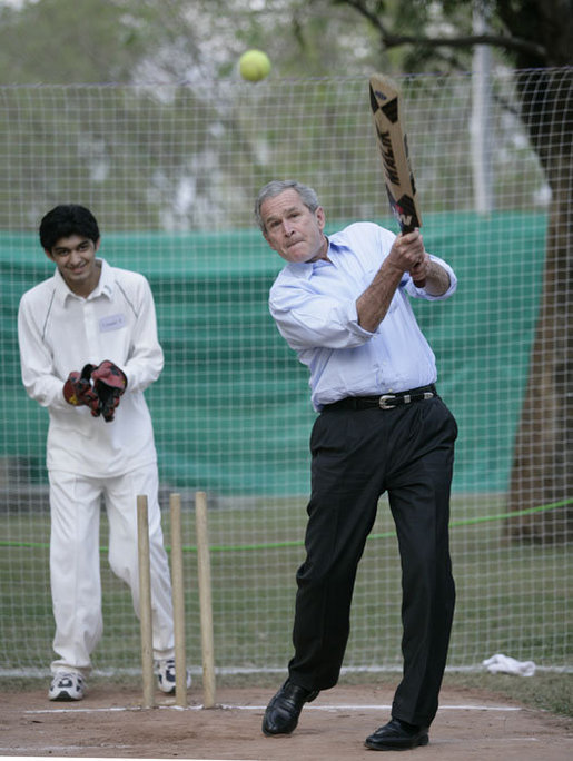 President George W. Bush watches his hit during a cricket clinic with Pakistani youth from the Schola Nova school and the Islamabad College for Boys, Saturday, March 4, 2006, at the Raphel Memorial Gardens on the grounds of the U.S. Embassy in Islamabad, Pakistan. White House photo by Eric Draper