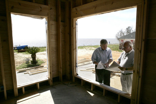 President George W. Bush looks over building plans with homeowner Jerry Akins at his home Wednesday, March 8, 2006 in Gautier, Miss., on the site where the Akins family is rebuilding their home destroyed by Hurricane Katrina. White House photo by Eric Draper
