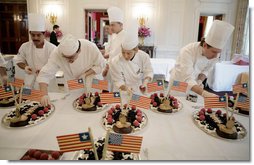 White House Executive Pastry Chef Thaddeus DuBois, center-background, supervises his staff, Tuesday, March 21, 2006, as they prepare the dessert trays for the social luncheon in honor of Liberia's President Ellen Johnson Sirleaf at the White House.  White House photo by Paul Morse